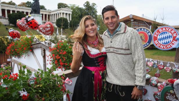 Ein Paar in Tracht posiert vor dem Oktoberfest in München.