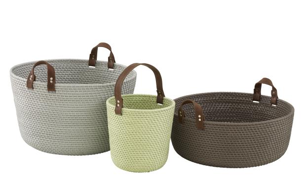 Drei verschiedenfarbige, geflochtene Körbe mit Ledergriffen stehen nebeneinander.