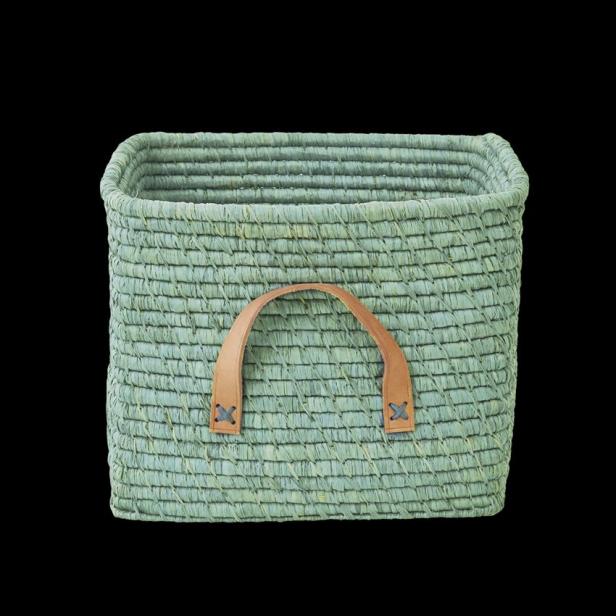 Ein quadratischer, hellgrüner Korb mit braunen Ledergriffen vor schwarzem Hintergrund.