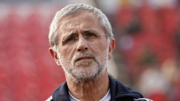 Ein Mann mit Brille und grauem Bart blickt nachdenklich zur Seite.