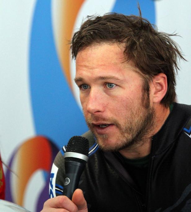 Bode Miller spricht in ein Mikrofon vor einem farbigen Hintergrund.