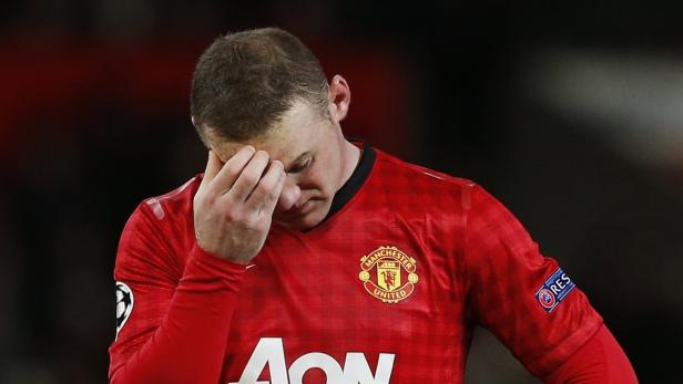 Wayne Rooney im Trikot von Manchester United mit gesenktem Kopf.