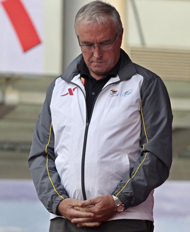 Ein Mann mit Brille und grauen Haaren blickt gesenkten Hauptes auf seine Hände.