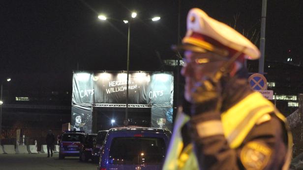 Ein Polizist telefoniert vor einem Veranstaltungsort für das Musical „Cats“.