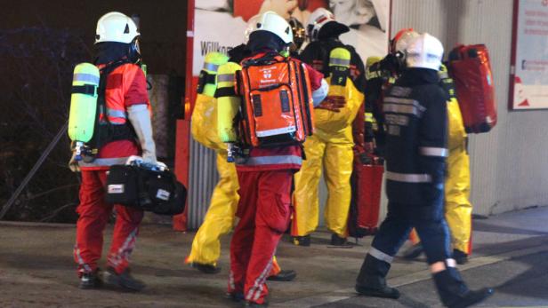Eine Gruppe von Feuerwehrleuten in Schutzkleidung geht zusammen.