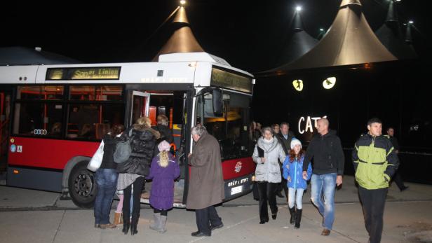 Menschen steigen nachts vor dem Musical „Cats“ aus einem Bus.