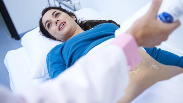 Eine Frau liegt bei einer Ultraschalluntersuchung auf einer Liege.