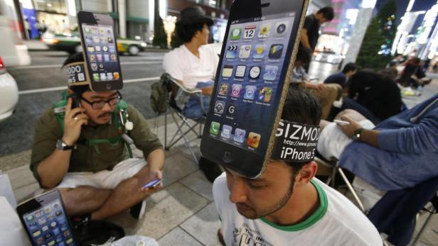 Menschen mit iPhone 5-Attrappen auf dem Kopf warten auf den Verkaufsstart.