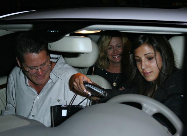 Drei Personen sitzen in einem Auto, eine Frau fährt.