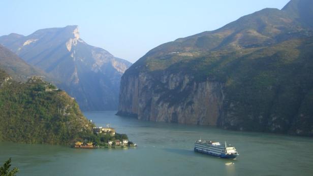 Ein Kreuzfahrtschiff fährt auf dem Jangtsekiang-Fluss durch die Drei Schluchten.