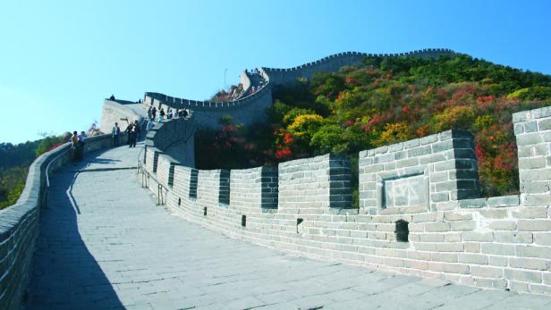 Menschen besuchen die Chinesische Mauer an einem sonnigen Tag.