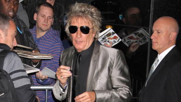 Rod Stewart gibt Autogramme für Fans.