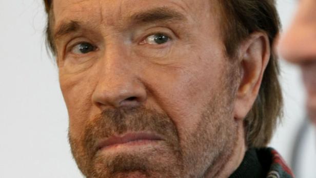 Nahaufnahme von Chuck Norris mit Bart und ernstem Blick.