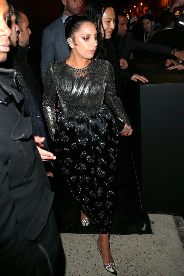 Lady Gaga in einem silbernen Oberteil und einem langen, schwarzen Rock mit Blumenmuster.