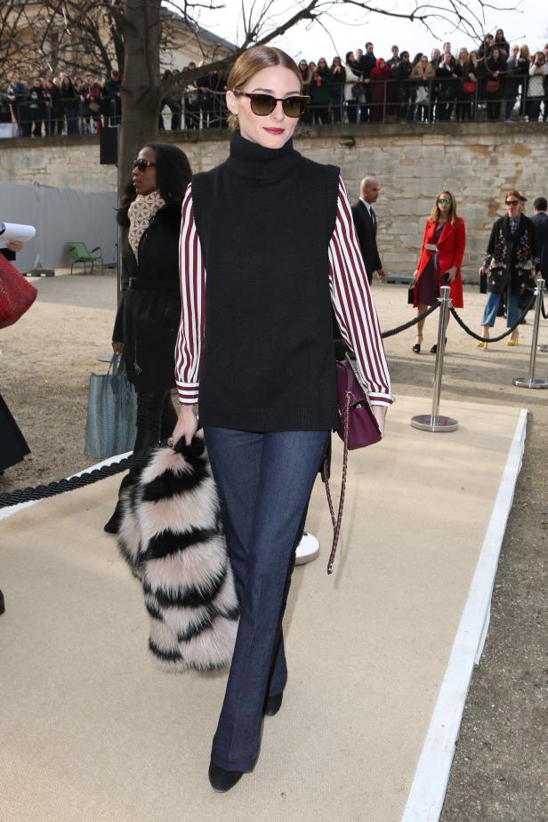 Olivia Palermo mit Sonnenbrille, Weste und Fellstola bei einer Modenschau.