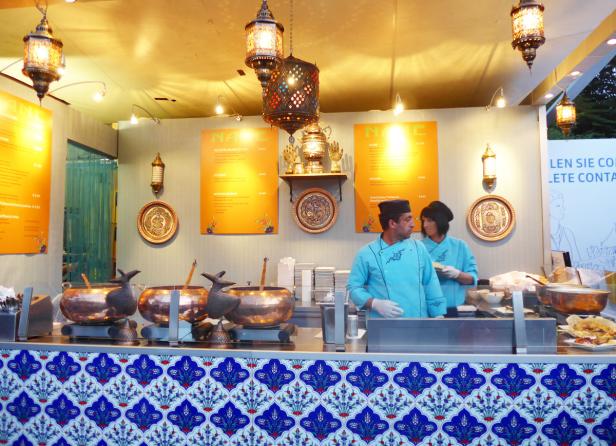 Zwei Köche stehen an einem Stand mit türkischen Spezialitäten.