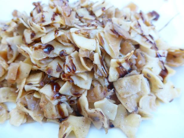 Ein Teller mit Schupfnudeln und dunkler Soße.