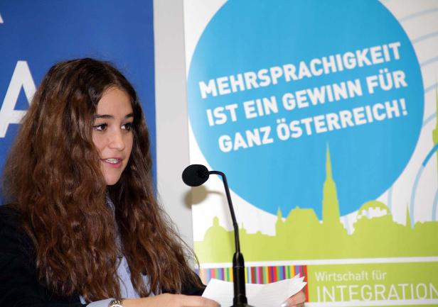 Eine junge Frau spricht bei einer Veranstaltung zum Thema Mehrsprachigkeit.