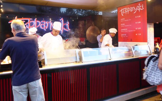 Köche bereiten Teppanyaki-Gerichte an einem Stand zu.