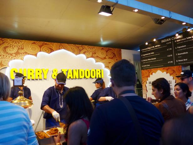 An einem Stand werden Curry und Tandoori-Gerichte zubereitet und verkauft.