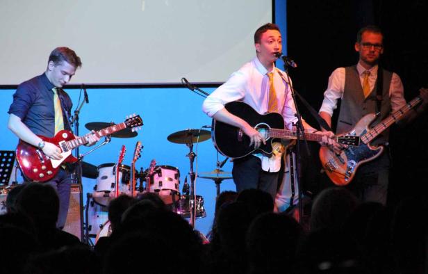 Eine Band spielt live vor Publikum auf einer Bühne.