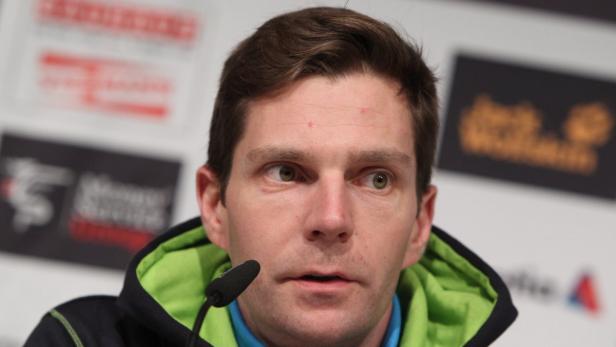 Ein Mann mit Mikrofon bei einer Pressekonferenz.