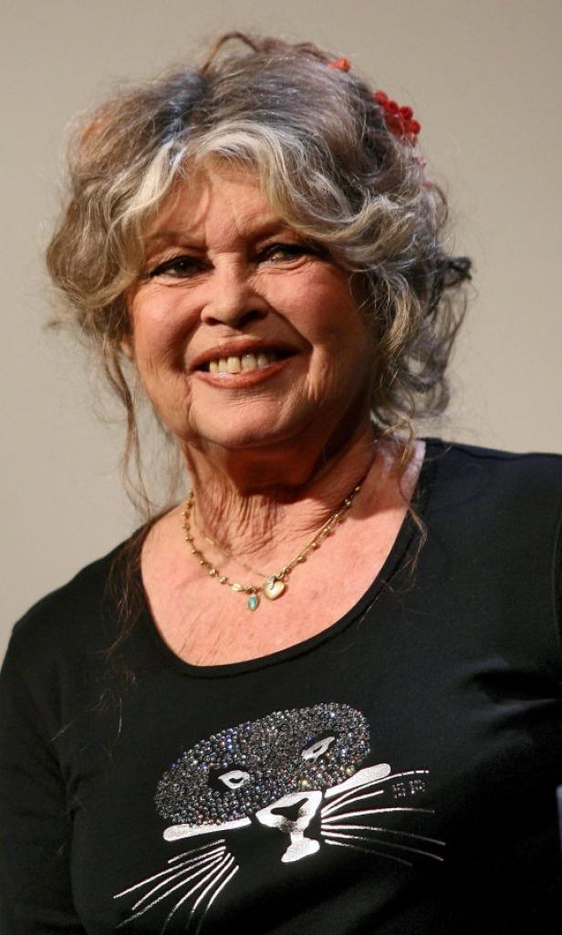 Brigitte Bardot lächelt in einem schwarzen T-Shirt mit Katzenmotiv.