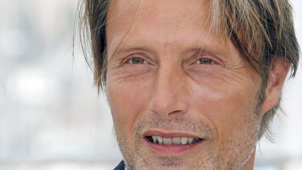 Nahaufnahme von Mads Mikkelsen mit blond gesträhnten Haaren.