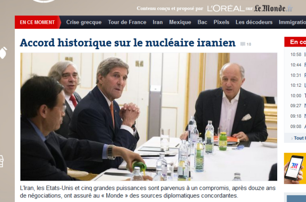 Mehrere Personen, darunter John Kerry, sitzen an einem Tisch bei einer Besprechung.