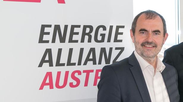 Ein Mann steht vor einem Schild der „Energie Allianz Austria“.