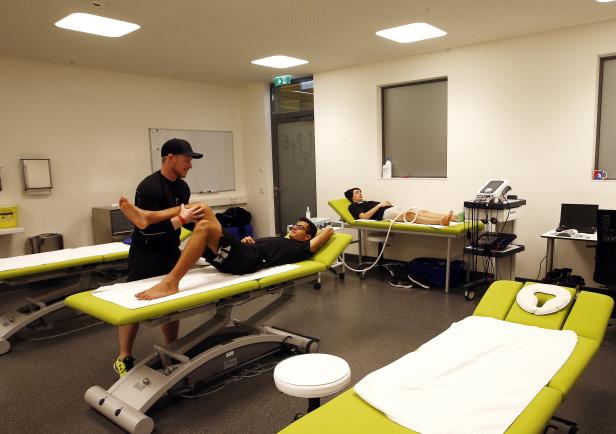 Ein Physiotherapeut behandelt einen Patienten in einer Praxis.