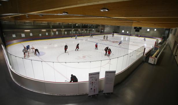 Eishockeyspieler trainieren in einer Halle auf dem Eis.
