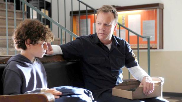 Sutherland wird vom Helden in "24" zum Loser in der neuen Serie "Touch". Ein Mann und ein Junge sitzen auf einer Bank in einem Gebäude.