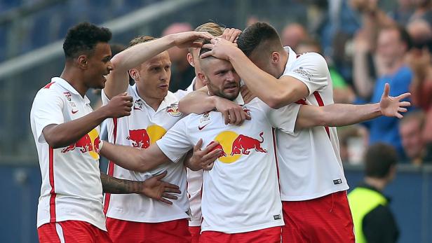 Eine Gruppe Fußballspieler umarmt sich auf dem Spielfeld.
