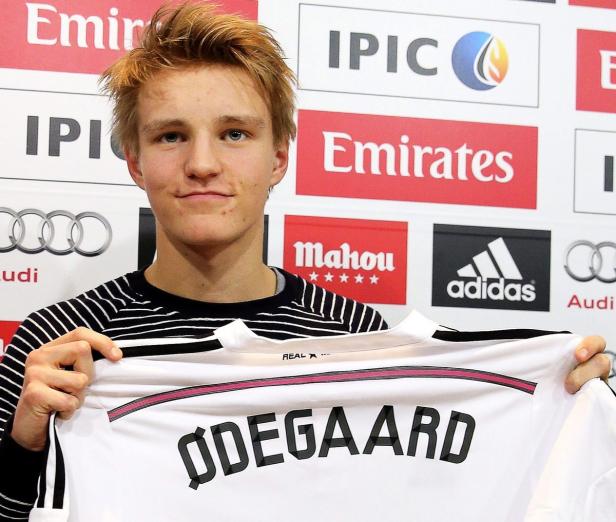 Martin Ødegaard hält ein Trikot von Real Madrid mit seinem Namen hoch.