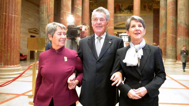 Heinz Fischer mit zwei Frauen in einem Gebäude mit Säulen.