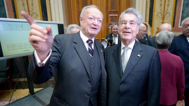 Heinz Fischer und ein weiterer Mann in Anzügen stehen zusammen.
