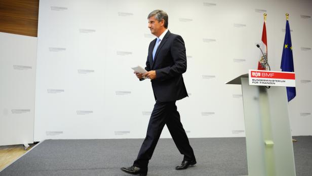 Ein Mann im Anzug geht an einem Rednerpult des Bundesministeriums für Finanzen vorbei.