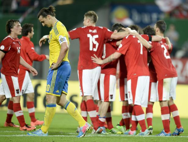 Zlatan Ibrahimović verlässt enttäuscht das Fußballfeld, während das österreichische Team jubelt.