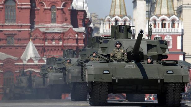 Russian servicemen stand atop T-14 tanks with the