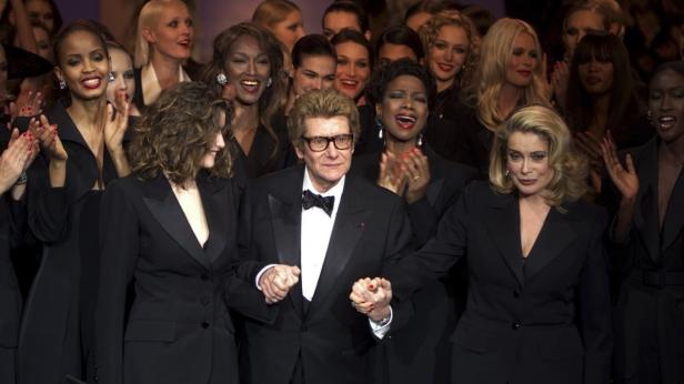 Yves Saint Laurent mit Models und Catherine Deneuve bei einer Modenschau.