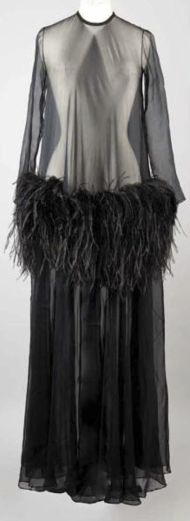 Ein langes, schwarzes Kleid mit Federnbesatz wird auf einer Schneiderpuppe präsentiert.