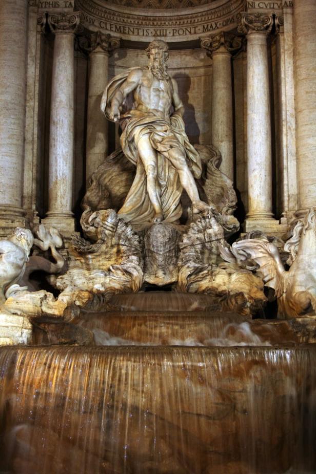 Die Fontana di Trevi zeigt eine Statue von Neptun inmitten von fließendem Wasser.