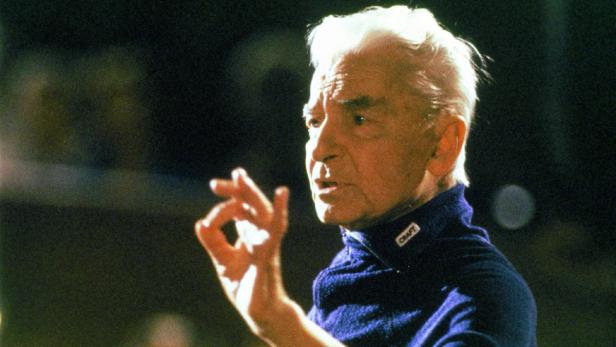 Leonard Bernstein dirigiert ein Orchester.