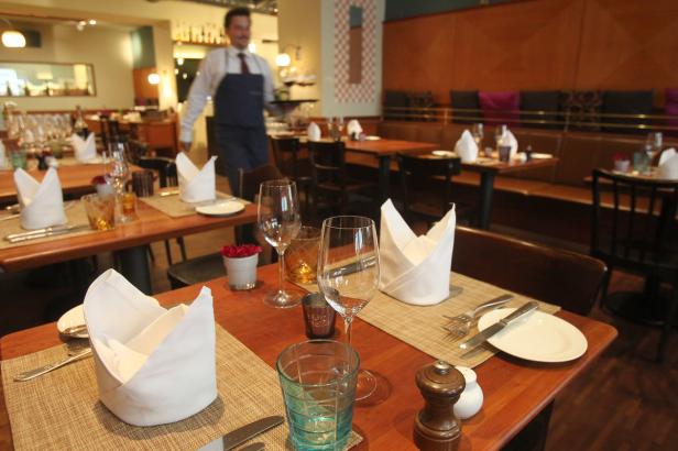 Ein Kellner serviert in einem elegant gedeckten Restaurant.