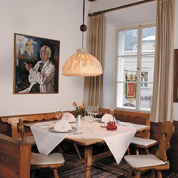 Ein gedeckter Tisch in einem traditionellen Restaurant mit einem Gemälde an der Wand.