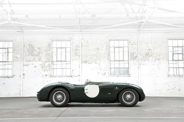 Ein grüner Jaguar C-Type Oldtimer steht in einer Lagerhalle.
