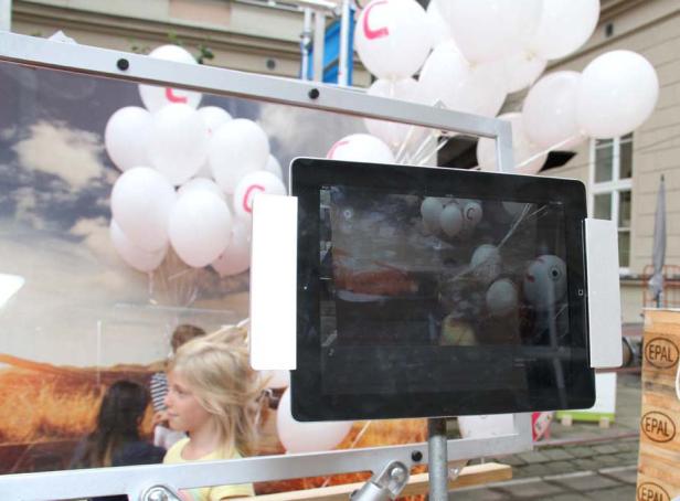 Ein iPad zeigt ein Foto von weißen Ballons mit dem Buchstaben C darauf.