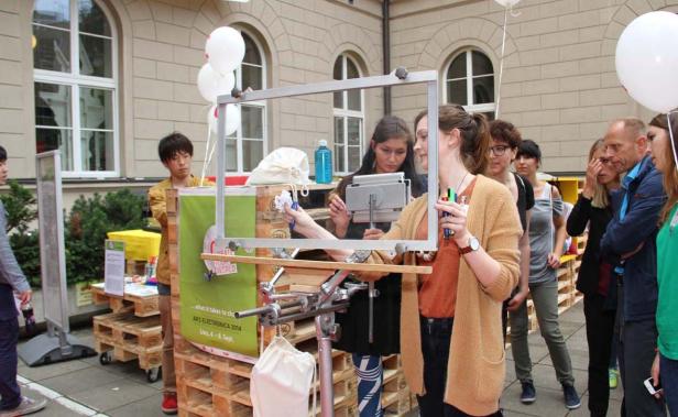 Eine Gruppe von Menschen steht um einen Stand von Ars Electronica 2014.