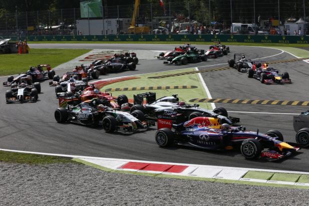 Mehrere Formel-1-Autos fahren auf einer Rennstrecke in einer Kurve.